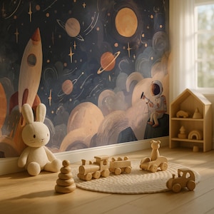 Op de afbeelding: Een kinderkamer met een ruimte-thema muurschildering met planeten en sterren. Een pluchen konijn zit naast houten speelgoed, waaronder een trein, een auto en stapelringen. Een houten huisvormige plank bevat meer speelgoed.