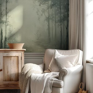 May include: A white armchair with a throw blanket and pillow, set in a room with a green and gray forest mural, a wooden cabinet, and a woven basket.