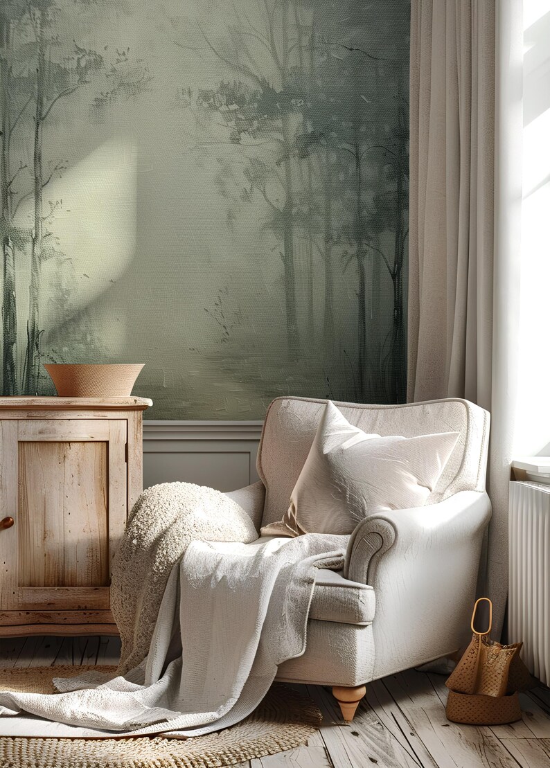 May include: A white armchair with a throw blanket and pillow, set in a room with a green and gray forest mural, a wooden cabinet, and a woven basket.