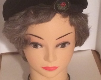 Black velvet beret with needlework pin