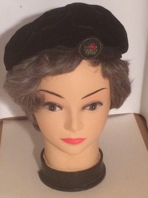 Black velvet beret with needlework pin