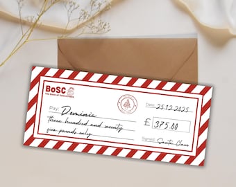 Può includere: Un assegno natalizio di fantasia della Banca di Babbo Natale, con un bordo a righe rosse e bianche. L'assegno è intestato a "Dominic" per £375,00, datato 25/12/2025 e firmato da Babbo Natale. Una busta marrone è sullo sfondo.