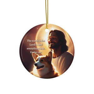 May include: A round ceramic ornament with a painting of Jesus and a corgi dog. The background is a golden glow. The text on the ornament reads "The earth is the Lord's, and everything in it. Psalm 24:1".