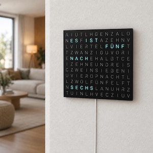 Könnte beinhalten: Eine quadratische schwarze Wanduhr mit einem Raster aus weißen Buchstaben. Die Uhr zeigt die Zeit mit leuchtend hellblauem Text an, der ES IST NACH FÜNF SECHS lautet. Ein weißes Stromkabel verläuft von der Unterseite der Uhr die Wand hinunter.
