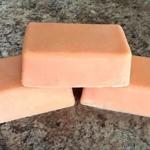 May include: Three bars of peach-colored soap stacked on top of each other.