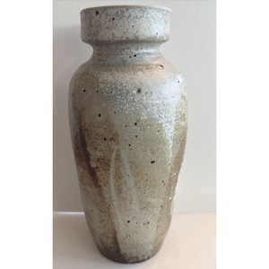 May include: A tall, speckled ceramic vase with a wide base and a narrow neck. The vase has a light gray and brown color scheme with dark speckles throughout. The vase is approximately 12 inches tall.