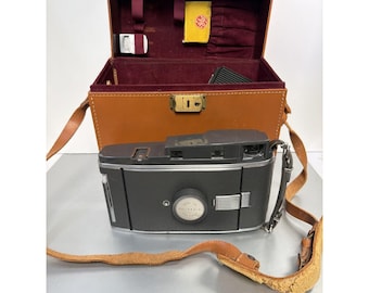 Fotocamera Polaroid Land modello 150 in custodia di pelle con accessori (non testata).