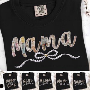 May include: Black t-shirt with the word "Mama" in a textured, multi-colored font, embellished with a pearl bow and a gold heart. Additional shirts below display "Baby Girl", "Gigi", "Mimi", "Mom", and "Nana".