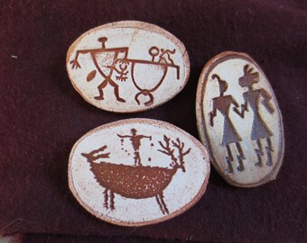 Conjunto de tres pines de arte rupestre tribal