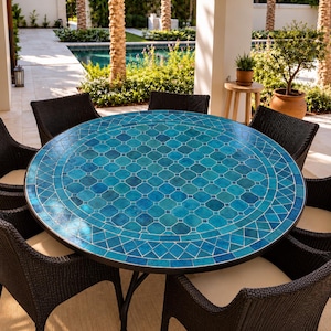 Puede incluir: Una mesa de comedor redonda con un tablero de mosaico turquesa vibrante con un patrón geométrico, apoyada sobre una estructura de metal oscuro, rodeada por seis sillas de mimbre trenzado marrón oscuro con cojines beige claro en un patio.
