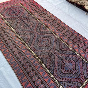 Pode incluir: Uma caneca de cerâmica branca com uma alça preta e o texto "But First, Coffee" em negrito preto. A caneca está sobre um fundo neutro, destacando seu design simples.
