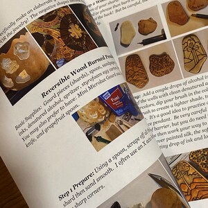 Op de afbeelding: Een boek met instructies voor het maken van omkeerbare gebrande houten hangers. Het boek bevat een lijst met benodigdheden, stappen voor het voorbereiden van de kalebas en het branden van het hout. Het boek bevat ook foto's van de afgewerkte hangers.