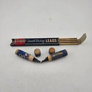 May include: An assortment of vintage writing supplies, including a box of Scripto Smooth Writing Leads and two containers of Staedtler Inc. leads. The containers are blue and tan, with the text "LEADS" and "Scripto" visible.