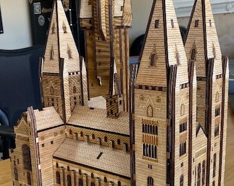 Könnte beinhalten: Ein detailliertes Holzmodell von Hogwarts, einer fiktiven Schule für Hexerei und Zauberei aus der Harry-Potter-Reihe. Das Modell besteht aus lasergeschnittenem Holz und verfügt über komplizierte Details, darunter Türme, Fenster und Türen.