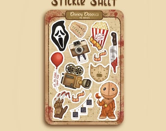 Op de afbeelding: Een stickervel met horror-thema illustraties, waaronder een Scream-masker, popcorn, een camera, een mes en een rode ballon. De tekst "WE ALL FLOAT DOWN HERE" is aanwezig. Het vel is gelabeld met "STICKER SHEET" en "DANDY DOODLES".