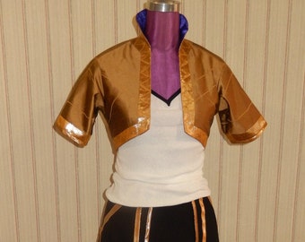 Op de afbeelding: Een wit shirt met een gouden en zwarte rok en een gouden getailleerd jasje. De outfit is op een mannequin.