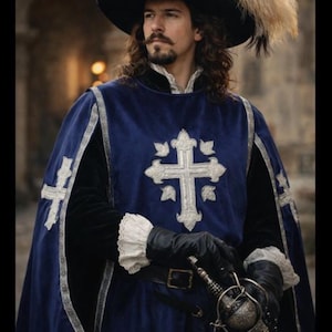 Puede incluir: Un hombre con vestimenta histórica, con un sombrero negro con pluma, una capa azul con una cruz plateada y guantes negros. Sostiene una espada, encarnando una estética clásica de época.