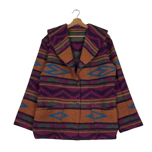 May include: A long-sleeved, brown, purple, green, and blue patterned jacket with a large collar and a button closure. The jacket has two pockets on the front.