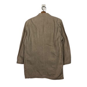 K&ouml;nnte beinhalten: Ein brauner Blazer aus Leinen mit einem einzigen Knopfverschluss und langen &Auml;rmeln.