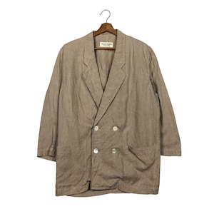 K&ouml;nnte beinhalten: Ein hellbrauner Blazer aus Leinen mit doppelreihigem Verschluss und zwei Eingrifftaschen. Der Blazer tr&auml;gt ein Etikett mit der Aufschrift "Made in China" und "100% Linen".