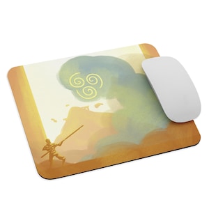 May include: A yellow and orange mousepad with a stylized image of a person holding a staff in front of a swirling cloud with a yellow symbol. The symbol is a stylized representation of the four elements of air, water, earth, and fire.