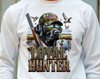 May include: White long-sleeve shirt with a black labrador retriever wearing sunglasses and a camouflage hat with an American flag. The dog is surrounded by ducks and the text "LOYAL HUNTER" is printed on the shirt.