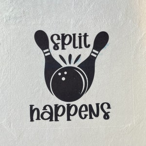 May include: White towel with a black bowling pin graphic and the text "Split happens".