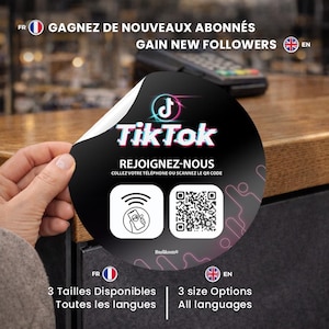 Peut inclure: Un autocollant TikTok noir et blanc avec le logo TikTok et le texte "REJOIGNEZ-NOUS". L'autocollant comprend également un code QR et le texte "COLLEZ VOTRE TÉLÉPHONE OU SCANNEZ LE QR CODE". L'autocollant est tenu par une main.