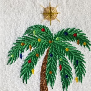 Puede incluir: Palmera de Navidad bordada con hojas verdes, un tronco marrón y adornos coloridos. Una estrella dorada se coloca en la parte superior del árbol.