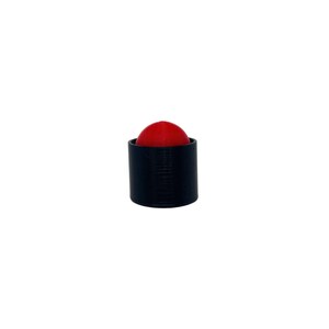 May include: A black bottle stopper with a red, spherical top. The stopper has a cylindrical shape and a textured surface. The red sphere is centered within the black cylinder.