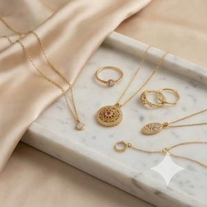 K&ouml;nnte beinhalten: Eine Auswahl an goldfarbenem Schmuck, darunter Halsketten, Ringe und Anh&auml;nger, ist auf einem Marmortablett angeordnet. Die Halsketten haben zarte Ketten und verschiedene Anh&auml;ngerdesigns, darunter ein diamantf&ouml;rmiger Anh&auml;nger. Die Ringe haben kleine, klare Steine.
