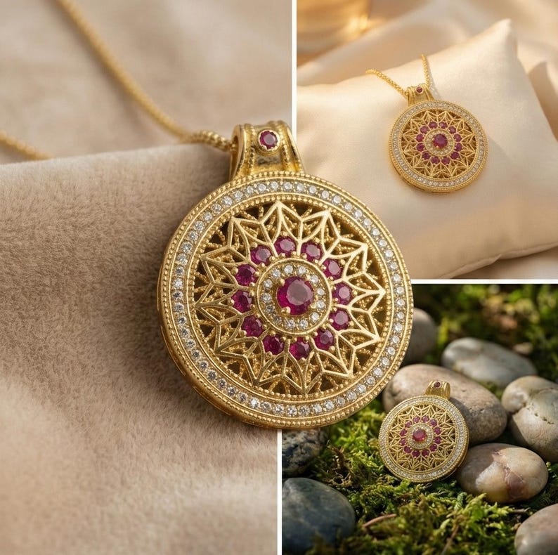 K&ouml;nnte beinhalten: Goldfarbene Anh&auml;nger-Halskette mit kreisf&ouml;rmigem Design. Der Anh&auml;nger hat einen zentralen Rubin, der von kleineren Rubinen und klaren Kristallen umgeben ist. Der &auml;u&szlig;ere Rand ist mit weiteren Kristallen besetzt und h&auml;ngt an einer zarten Goldkette.