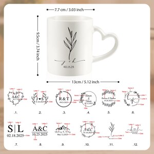 Op de afbeelding: Witte keramische mok met een hartvormig handvat, met een botanisch ontwerp en de initialen "j + h" met de datum "02.15.25". De mok is 9,5 cm hoog en 7,7 cm breed.