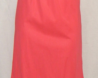 May include: A coral-colored slip skirt with an elastic waistband and a scalloped lace hem. The skirt is made of a smooth, lightweight fabric and falls to the mid-calf.