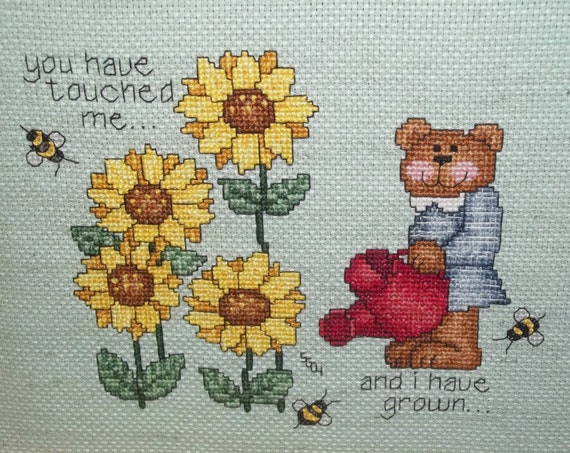 teddy bear holding a sunflower