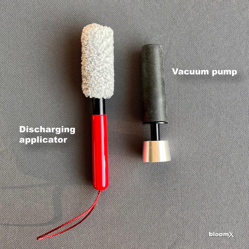May include: A red and black discharging applicator with a white fluffy tip and a black and silver vacuum pump.