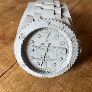 Ornamento Rolex in cemento
