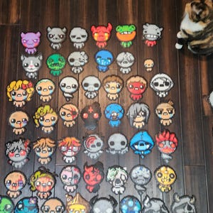 May include: A collection of 50 colorful pixel art characters, each with a unique design and expression. The characters are made of small beads and are arranged in a grid pattern.