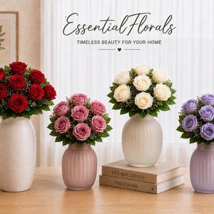May include: Four floral arrangements in ceramic vases featuring red, dusty pink, white, and lavender roses with green foliage. The text Essential Florals TIMELESS BEAUTY FOR YOUR HOME is displayed above the bouquets, which sit on a wooden surface.