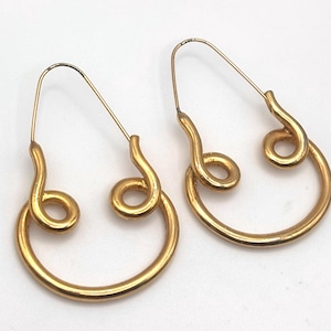 May include: A pair of gold-colored hoop earrings. Each earring features a curved wire that forms a teardrop shape, with a spiral design at the bottom. The earrings are made of a shiny, metallic material.