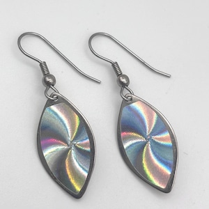 May include: A pair of silver-toned earrings. Each earring features a teardrop-shaped, iridescent center with a radial pattern. The earrings have a hook closure and a small, round bead detail. The overall design is simple and elegant.