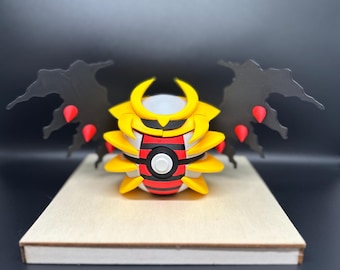 May include: A yellow and red Pokemon figure with black wings. The figure is standing on a wooden base.