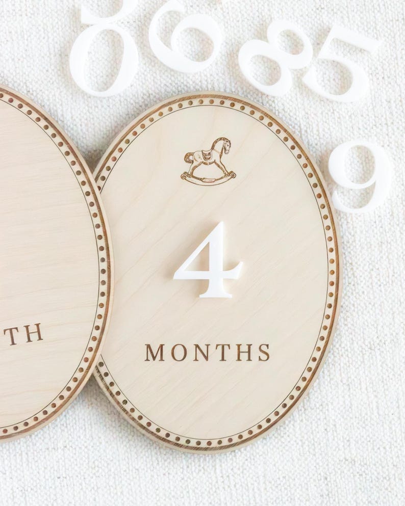 Handmade wooden baby milestone markers used as monthly photo props for newborn and infant pictures. Teddy bear themed month plaques highlight baby age and first year milestones from 1 month to 12 months. Neutral nursery decor for baby boy or gender neutral spaces, ideal baby shower gift and keepsake for first year baby photos.