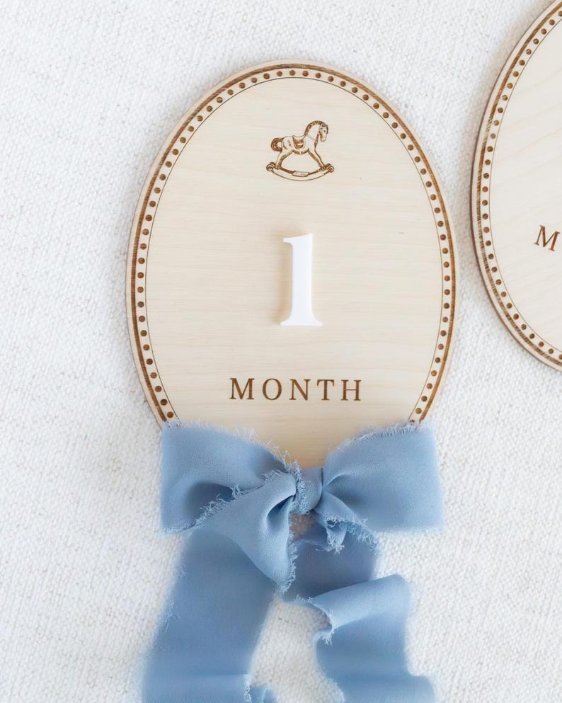 Handmade wooden baby milestone markers used as monthly photo props for newborn and infant pictures. Teddy bear themed month plaques highlight baby age and first year milestones from 1 month to 12 months. Neutral nursery decor for baby boy or gender neutral spaces, ideal baby shower gift and keepsake for first year baby photos.