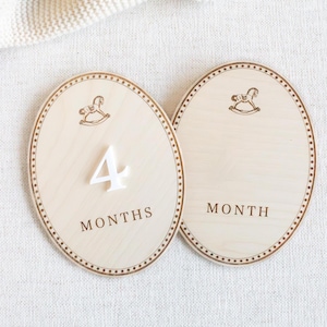 Wooden monthly baby milestone plaque placed next to baby during a photo session to mark baby age and growth. Newborn and infant monthly photo prop for first year milestones, baby month markers from 1 month to 12 months. Neutral teddy bear nursery theme, baby boy or gender neutral decor, baby shower gift, wooden milestone disc/plaques for monthly baby pictures.