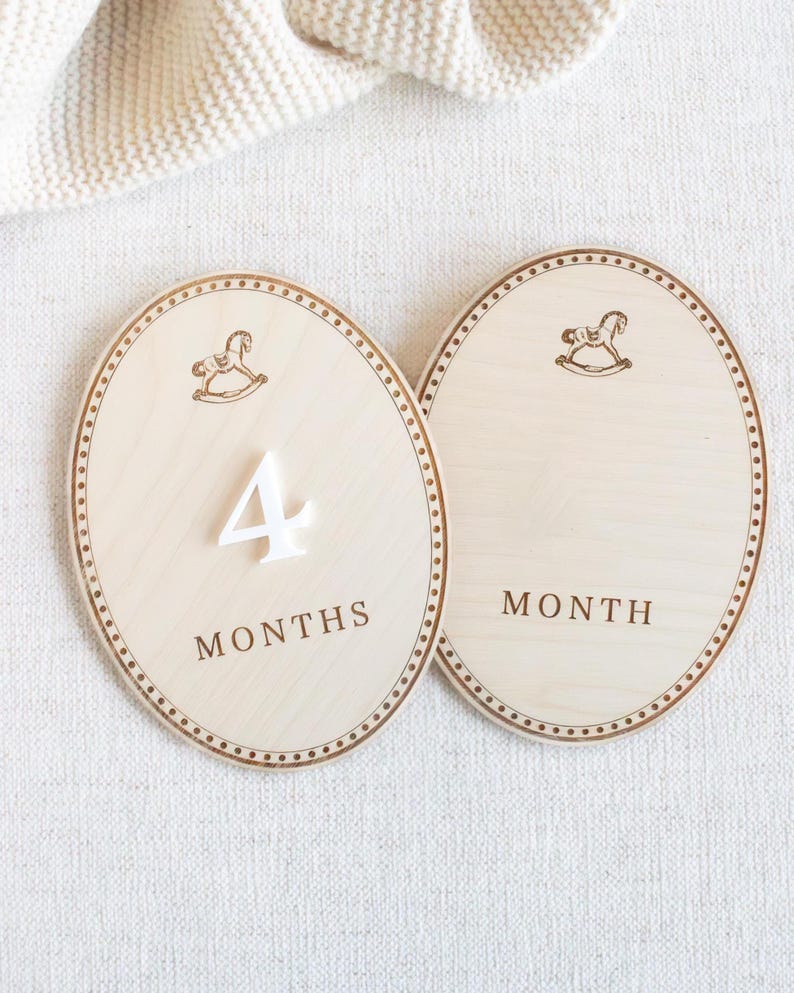 Wooden monthly baby milestone plaque placed next to baby during a photo session to mark baby age and growth. Newborn and infant monthly photo prop for first year milestones, baby month markers from 1 month to 12 months. Neutral teddy bear nursery theme, baby boy or gender neutral decor, baby shower gift, wooden milestone disc/plaques for monthly baby pictures.