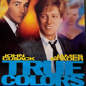 May include: Movie poster for the film "True Colors" starring John Cusack and James Spader. The poster features a blue and yellow color scheme with the title in large, bold letters. The actors' names are listed below the title in smaller font. The tagline reads "All the shades of friendship. Including betrayal and revenge."