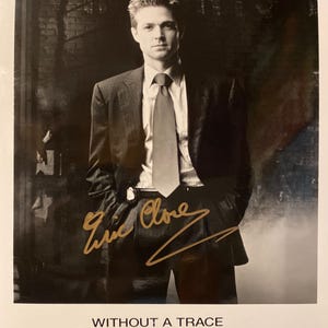 May include: Black and white photograph of a man in a suit and tie, with a signature in gold ink. The text "WITHOUT A TRACE" is at the bottom, with "Eric Close as Martin Fitzgerald" below it.