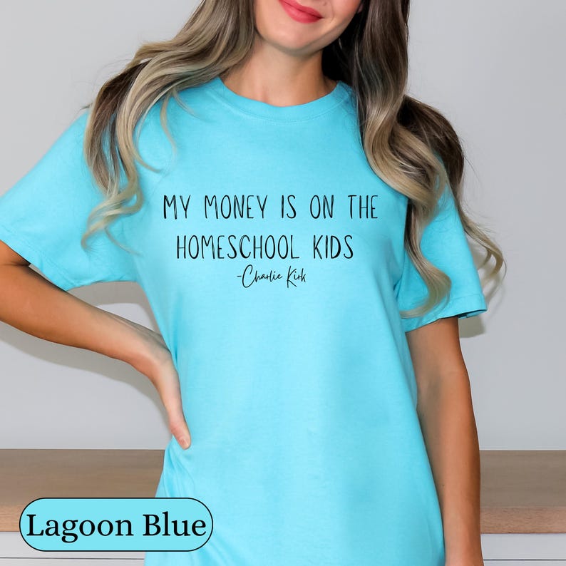 May include: Lagoon blue t-shirt with the text "MY MONEY IS ON THE HOMESCHOOL KIDS - Charlie Kirk" in black. The shirt is a solid color and has a round neckline.