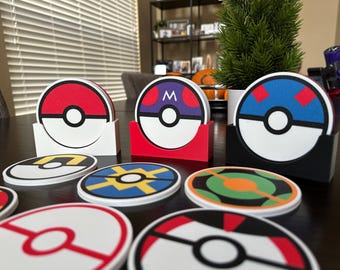 May include: A set of nine colorful round coasters featuring a Pokemon theme. The coasters have different designs, including a red and white Pokeball, a blue and white Pokeball with a red M, a blue and white Pokeball with red squares, and a yellow and blue Pokeball with a yellow lightning bolt. The coasters are made of a durable material and are perfect for protecting your furniture from spills and scratches.